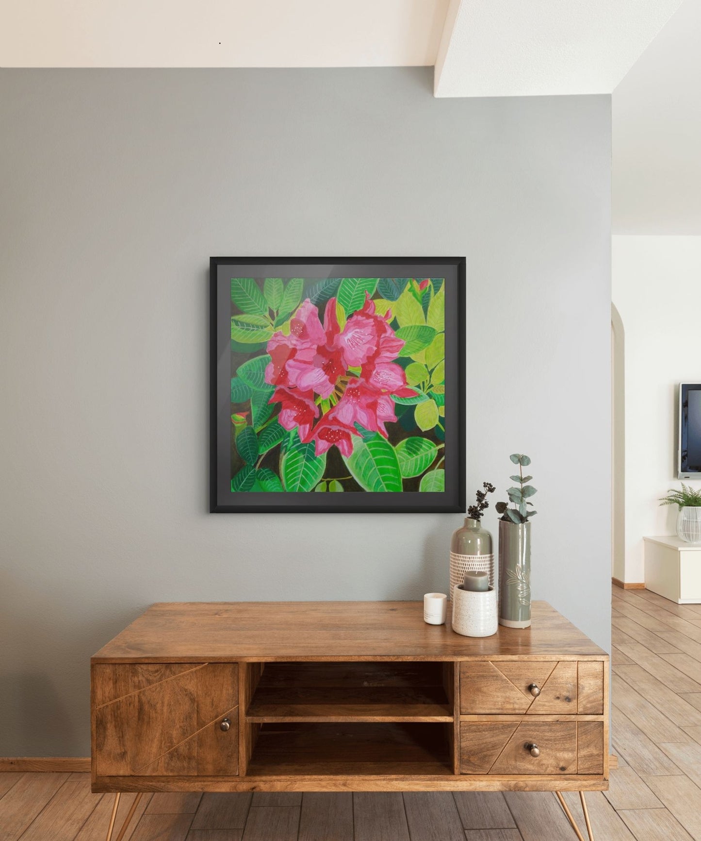 Éclat de Rhododendron expressive floral artwork by Nelleke Bruno displayed above a brown sideboard against a white wall, framed in black with a black mat board.