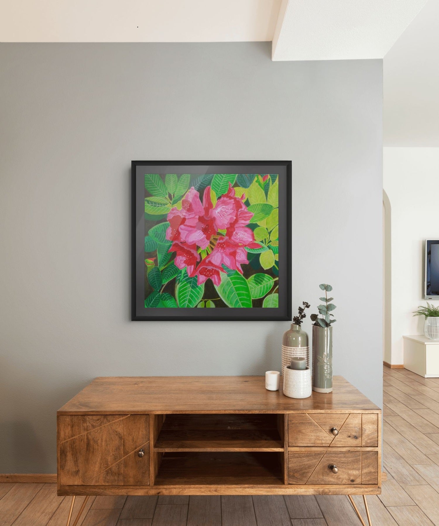Éclat de Rhododendron expressive floral artwork by Nelleke Bruno displayed above a brown sideboard against a white wall, framed in black with a black mat board.