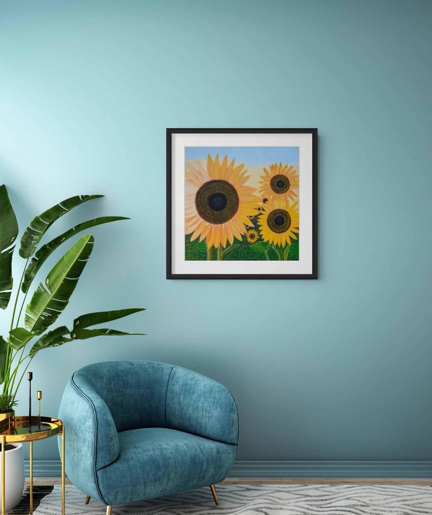 Éclat de Tournesol fine art print displayed in a contemporary living room with a blue chair and blue accent wall, bringing warmth, colour and a touch of French-inspired floral art.