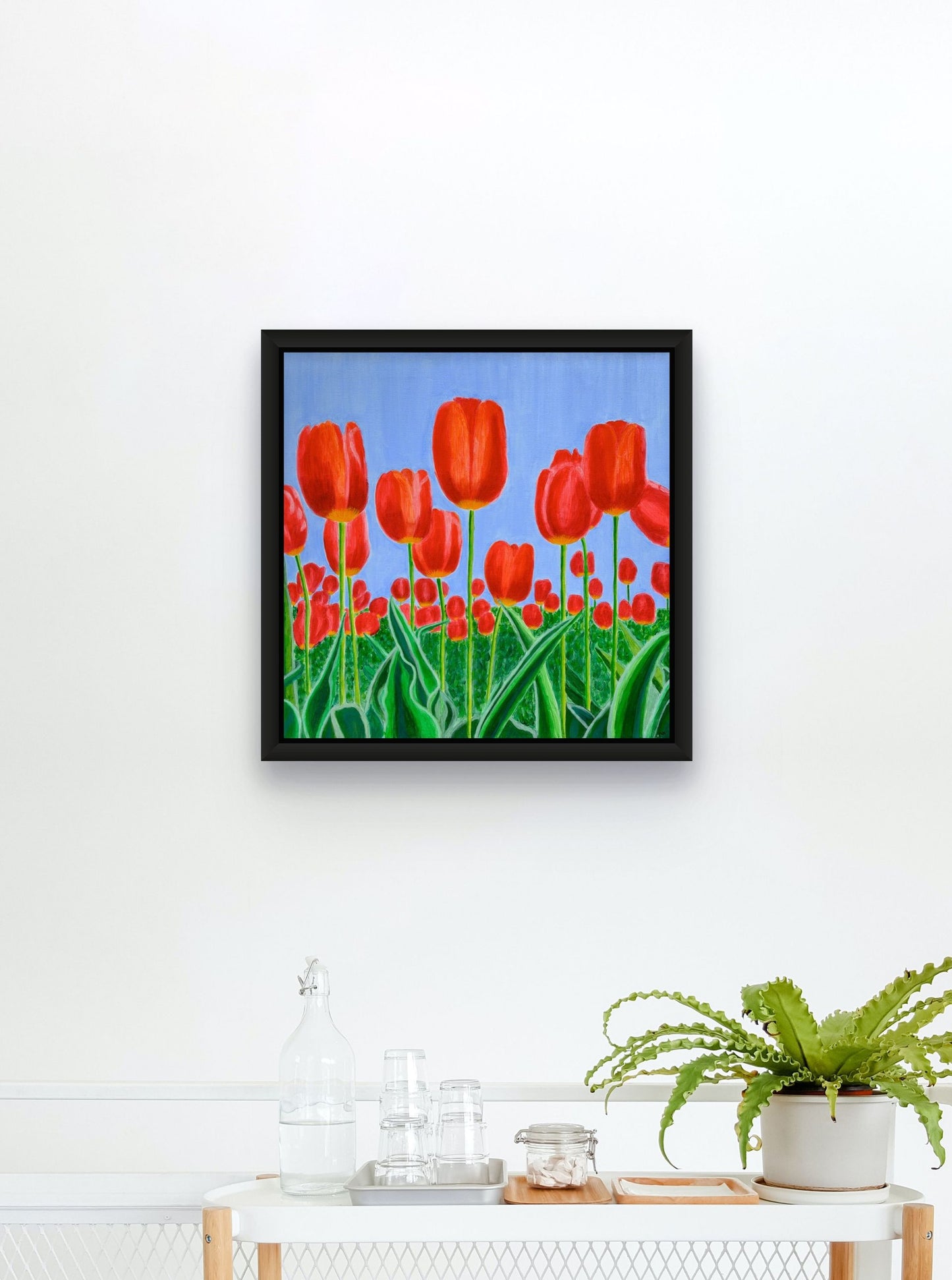 Éclat de Tulipes canvas print by Nelleke Bruno featuring vibrant red tulips, fresh green leaves, and a bright blue sky.