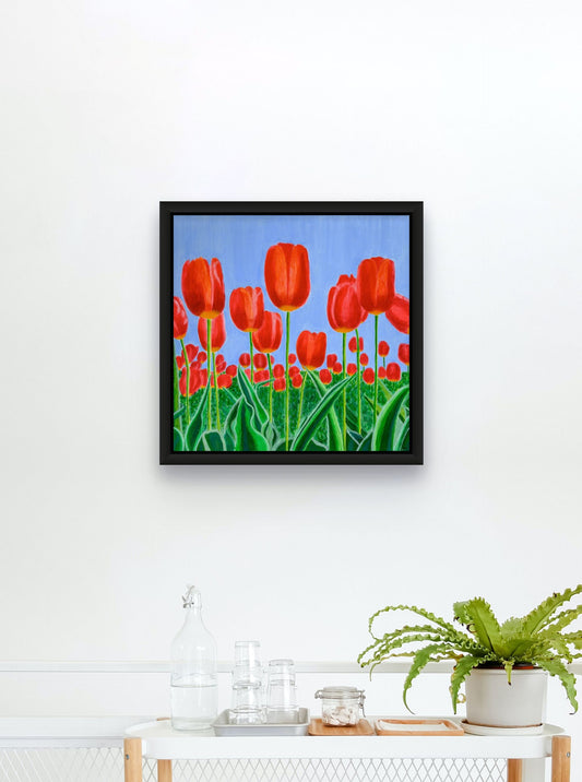 Éclat de Tulipes canvas print by Nelleke Bruno featuring vibrant red tulips, fresh green leaves, and a bright blue sky.