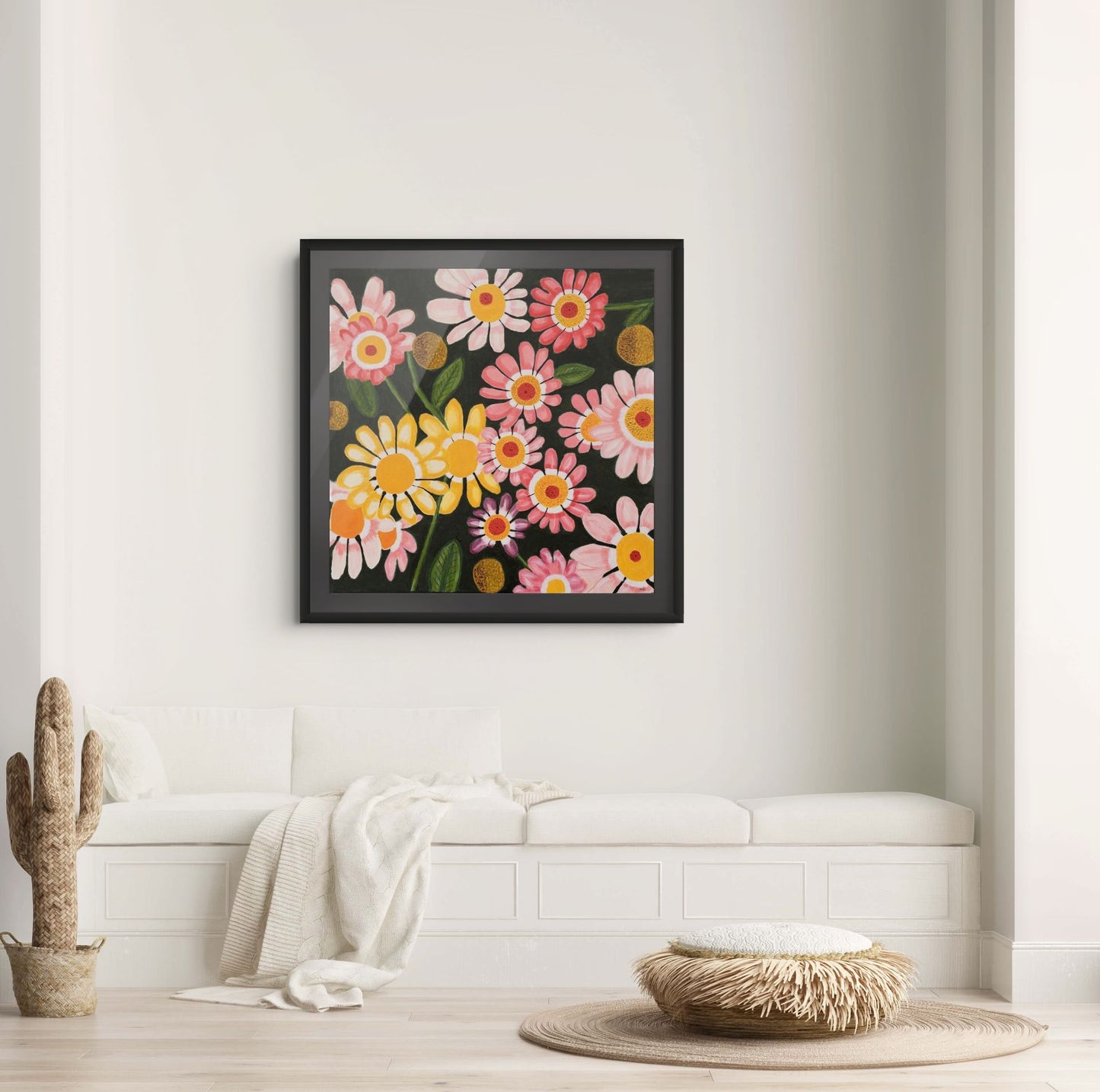 Éclat des Marguerites floral fine art print by Nelleke Bruno displayed above a white sofa against a white wall with a black frame and black passe-partout.